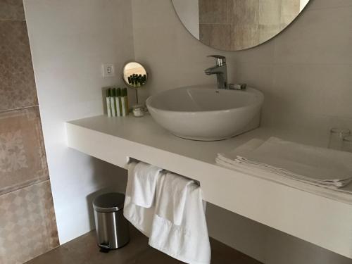 a white bathroom with a sink and a mirror at Casa Boquera in Carche