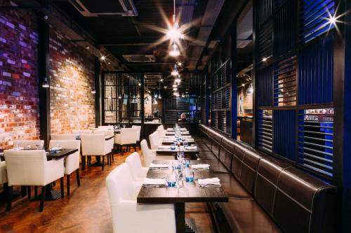 a dining room with tables and white chairs at mour hotel in Mansfield