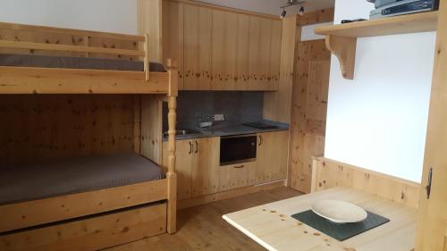 サメーダンにあるRelaxing confortable studio, heated garage, skiroomの二段ベッド2台とキッチンが備わる客室です。
