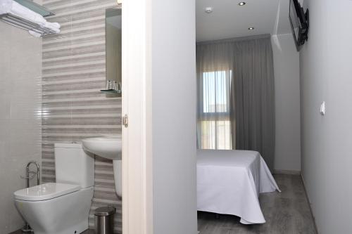 uma casa de banho branca com um WC e um lavatório em Hotel Siskets em Torrente de Cinca