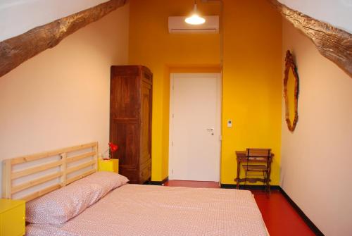 a bedroom with a bed and a yellow wall at Attic Hostel Torino in Turin
