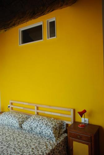 a yellow bedroom with a bed and a yellow wall at Attic Hostel Torino in Turin
