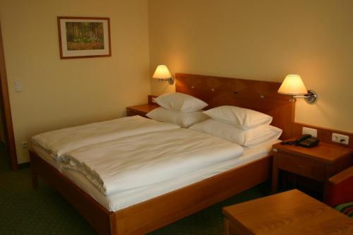 a bedroom with a large bed with two pillows at Badener Hof in Baden