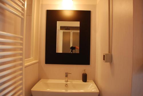 a bathroom with a sink and a mirror at Attic Hostel Torino in Turin