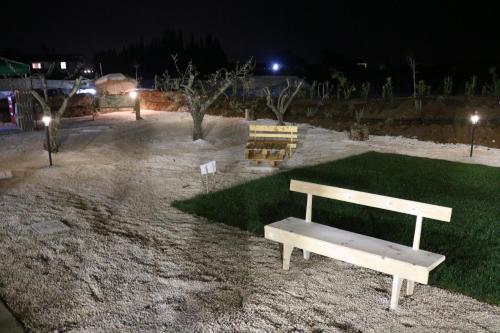 a white bench sitting in a park at night at Casa Mattia - B&B in Legno & Paglia in Cisterna di Latina