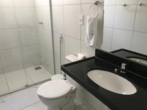 uma casa de banho com um WC, um lavatório e um chuveiro em Abrolhos Praia Hotel em Fortaleza