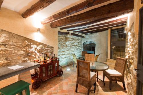 a room with a table and chairs and a stone wall at Hotel Rural El Pilaret in Azanúy