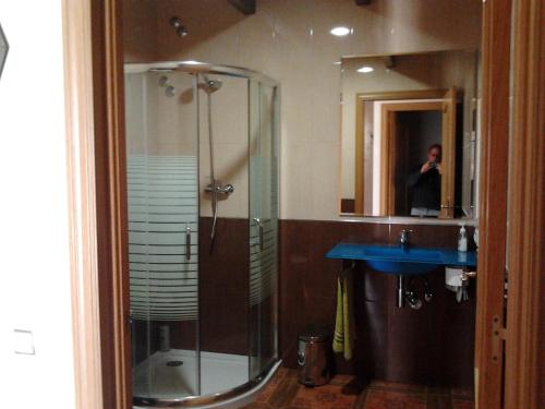 uma pessoa tirando uma foto de um chuveiro em uma casa de banho em Los Aladros em La Puebla de Valverde