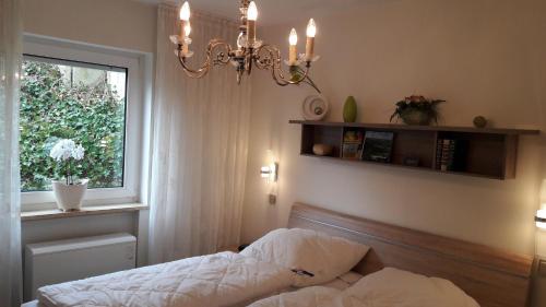 ヴィンターベルクにあるFerienwohnung Am Kleehagenのベッドルーム1室(ベッド1台、窓、シャンデリア付)