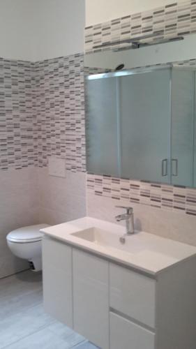 a white bathroom with a sink and a toilet at Residenza Christian in Gravedona