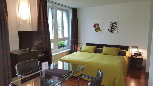 a bedroom with a bed and a tv and a window at Hotel Rebstock in Luzern