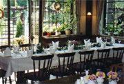 un comedor con mesas blancas, sillas y plantas en Landhotel Osterlamm, en Grünhain