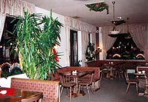 un restaurant avec des tables, des chaises et des plantes dans l'établissement Landhotel Osterlamm, à Grünhain