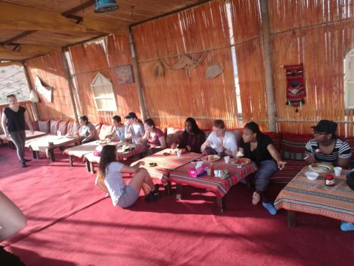 un grupo de personas sentadas en una habitación en Desert Retreat Camp en Al Wāşil