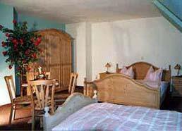 Schlafzimmer mit einem Bett, einem Tisch und Stühlen in der Unterkunft Landhotel Osterlamm in Grünhain
