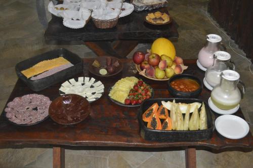 a table filled with different types of food on it at Pousada Recanto das Aves in Iguape
