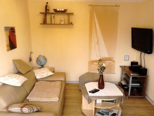 - un salon avec un canapé et une télévision dans l'établissement FERIENBUNGALOW Schwanck in Sagard, à Sagard
