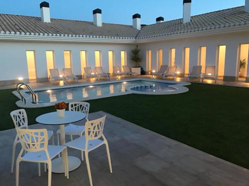 a patio with a table and chairs next to a pool at Casa Boquera in Carche