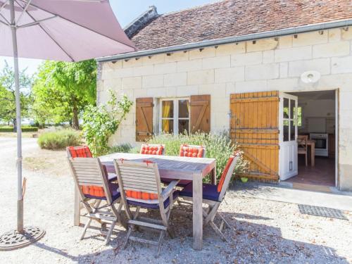 une table avec des chaises et un parasol devant une maison dans l'établissement Holiday Home in Montrichard with Pool, à Bourré
