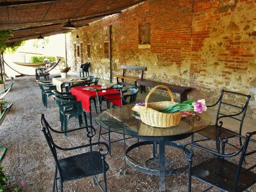 a patio with tables and chairs and a brick wall at Apartment near Lake Trasimeno vineyards in Strada