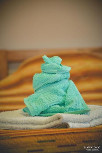 a folded blue towel sitting on top of a bed at Guest House Vila Banjica in Pirot