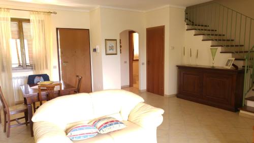a living room with a white couch and a staircase at Un Angolo di Paradiso in Spoleto