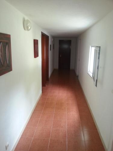an empty hallway with a door and a tile floor at Quinta da Barroquinha in Vale de Prazeres