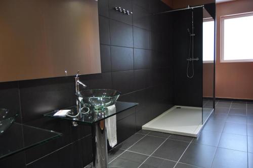 a black bathroom with a sink and a shower at Hotel Indiana in Pinto