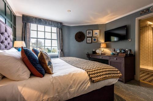 a bedroom with a large bed and a television at City Gate in Exeter