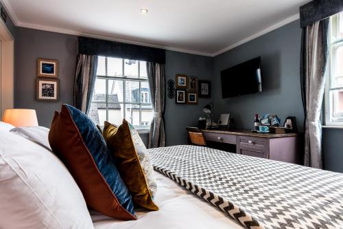 a bedroom with a bed with pillows and a television at City Gate in Exeter