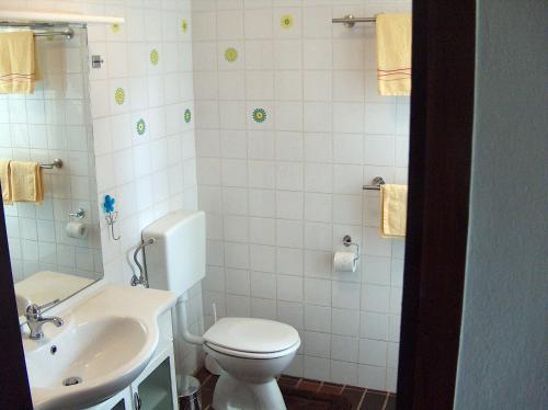 a white bathroom with a toilet and a sink at Guest House Mareda Palms in Novigrad Istria