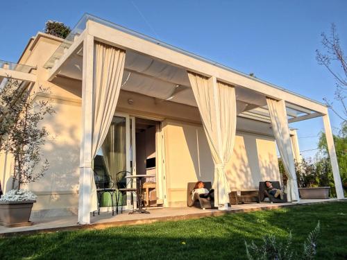 two people sitting on the porch of a house with curtains at B&B La Magia dei Sogni Relais in Verona
