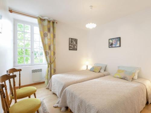 two beds in a room with a chair and a window at Elegant Escape in Lanrelas in Lanrelas