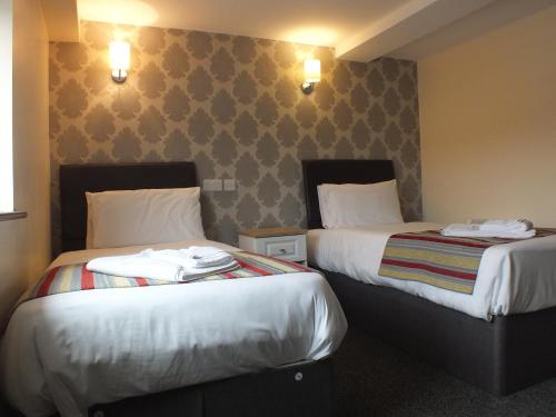 two beds sitting next to each other in a hotel room at The Fazeley Inn in Fazeley