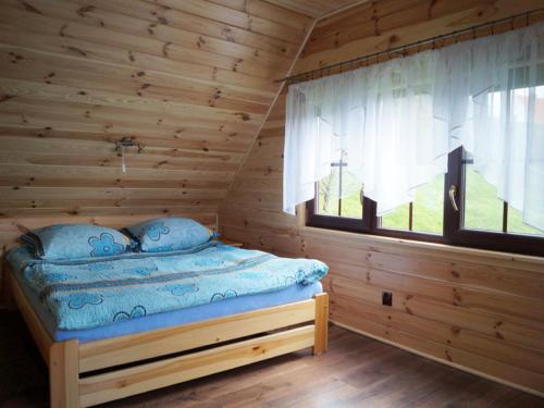 JeziorowskieにあるDomek Nad Jeziorem na Mazurach-Martaのログキャビン内のベッドルーム1室