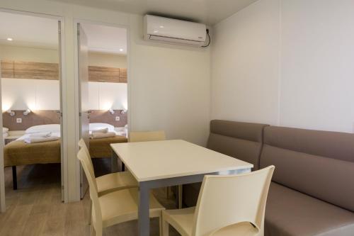 a room with a table and a couch and a bed at The Garda Village in Sirmione