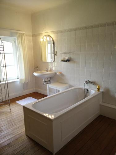une salle de bain blanche avec une baignoire et un lavabo dans l'établissement Château Mesny, à Vic-sur-Seille