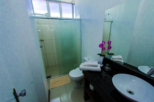a bathroom with a sink and a shower and a toilet at Hotel Palace Frederico in Frederico Westphalen