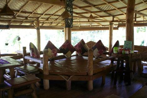 - une table en bois avec des oreillers dans l'établissement On The Rocks Bungalows, Restaurant and Jungle Trekking Tours, à Bukit Lawang