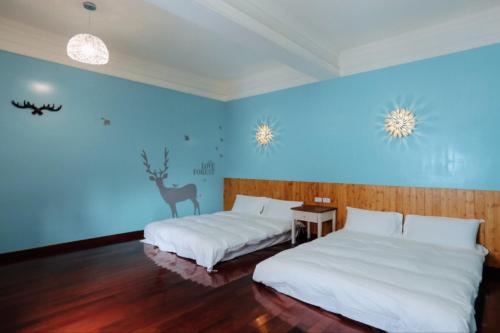 東港的住宿－嘉蓮小棧民宿 ，蓝色墙壁客房的两张床