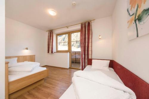 a room with two beds and a window at Haus Renate in Kaunertal