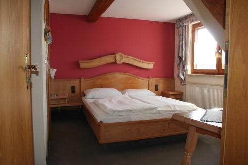 a bedroom with a bed with a red wall at Steiner Wirt in Tiefenbach