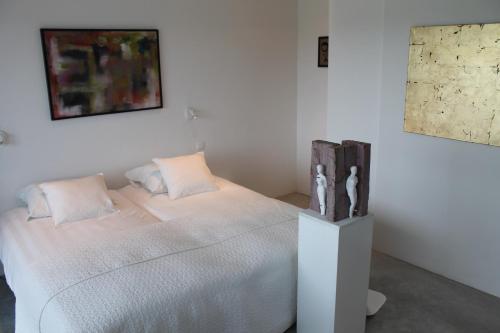 ein Schlafzimmer mit einem weißen Bett mit zwei Kissen in der Unterkunft B&B Het Museum in Berlaar