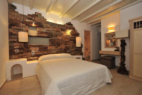 a bedroom with a brick wall and a bed at Villa Isabella in Naousa