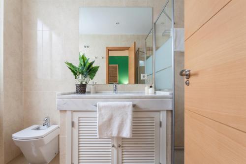 a bathroom with a sink and a toilet and a mirror at Soho Lounge - Space Maison Apartments in Seville
