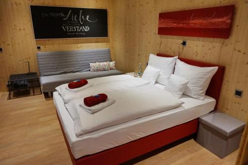 a bedroom with a large white bed with two red pillows at mein kleinHOTEL in Herbstein