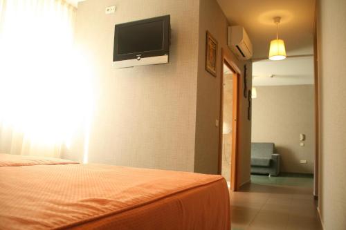 a bedroom with a bed and a flat screen tv on the wall at Hotel Indiana in Pinto