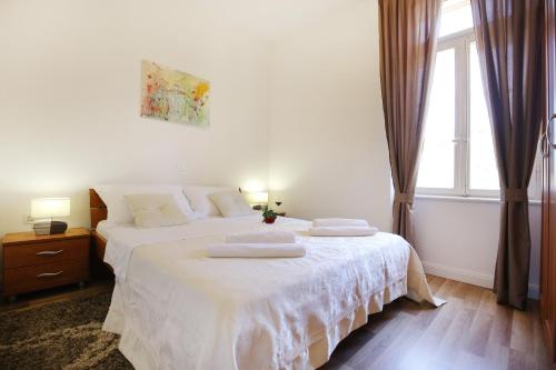 a bedroom with a white bed with two pillows on it at Bay View Apartment in Zadar