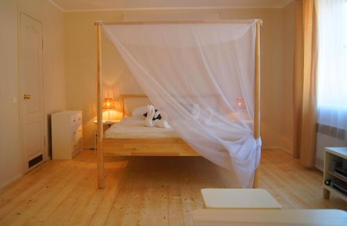 a bedroom with a bed with a mosquito net at Guest House Vasara in Nida
