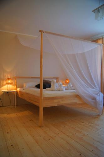 a bedroom with a bed with a mosquito net at Guest House Vasara in Nida